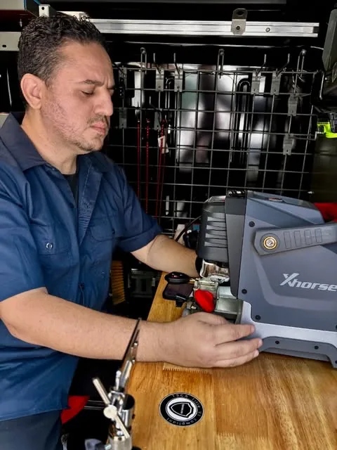 Adam cutting a car key on the key machine inside the Hub Key Services van