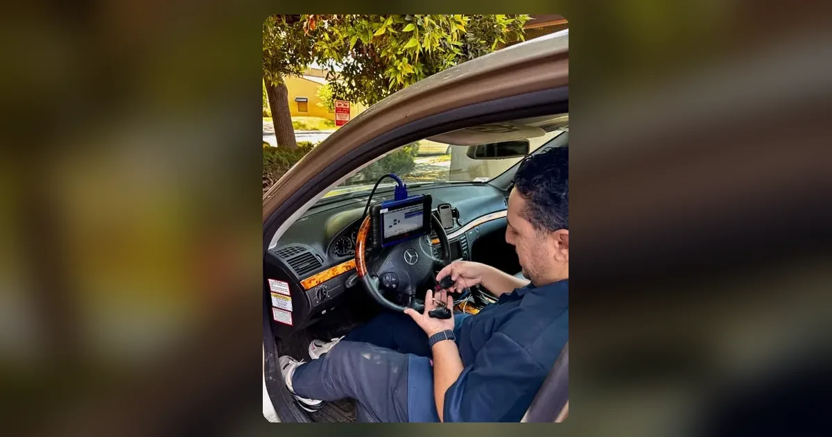 Adam from Hub Key Services working on a customer’s car key inside the car